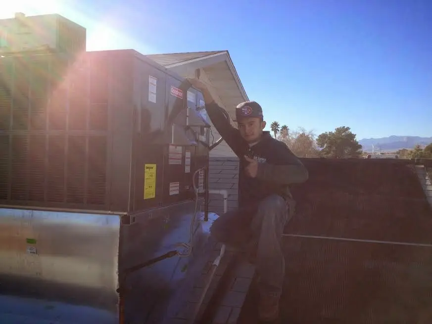 HVAC technician performing Air Duct Repair on a rooftop unit in Barnhart